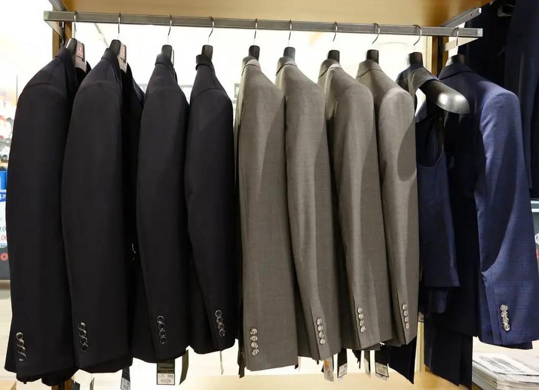 Le vêtement doit être uni, sans motif apparent, avec un tissu sobre et mat. Privilégiez les matières comme le coton mélangé ou la laine fine en hiver. Évitez satin, velours à reflets ou brocart, car ils peuvent paraître trop ostentatoires.